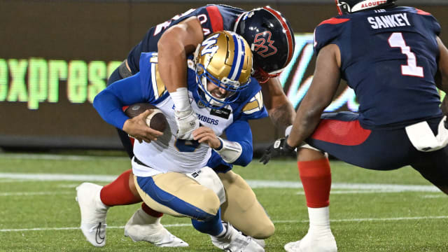 Nov 19, 2023; Hamilton, Ontario, CAN; Winnipeg Blue Bombers quarterback Zach Collaros (8) is tackled by Montreal Alouettes defensive lineman Mustafa Johnson (4) in the first half at Tim Hortons Field. Johnson was penalized for unnecessary roughness on the play. Mandatory Credit: Dan Hamilton-USA TODAY Sports  
